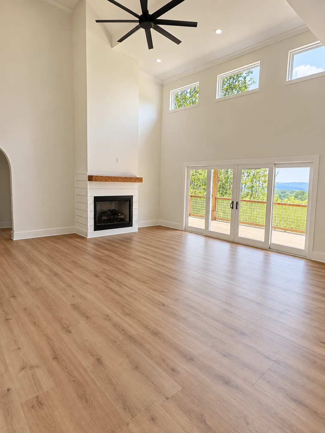 Fox Hill vaulted living room with a fireplace and glass doors to the porch