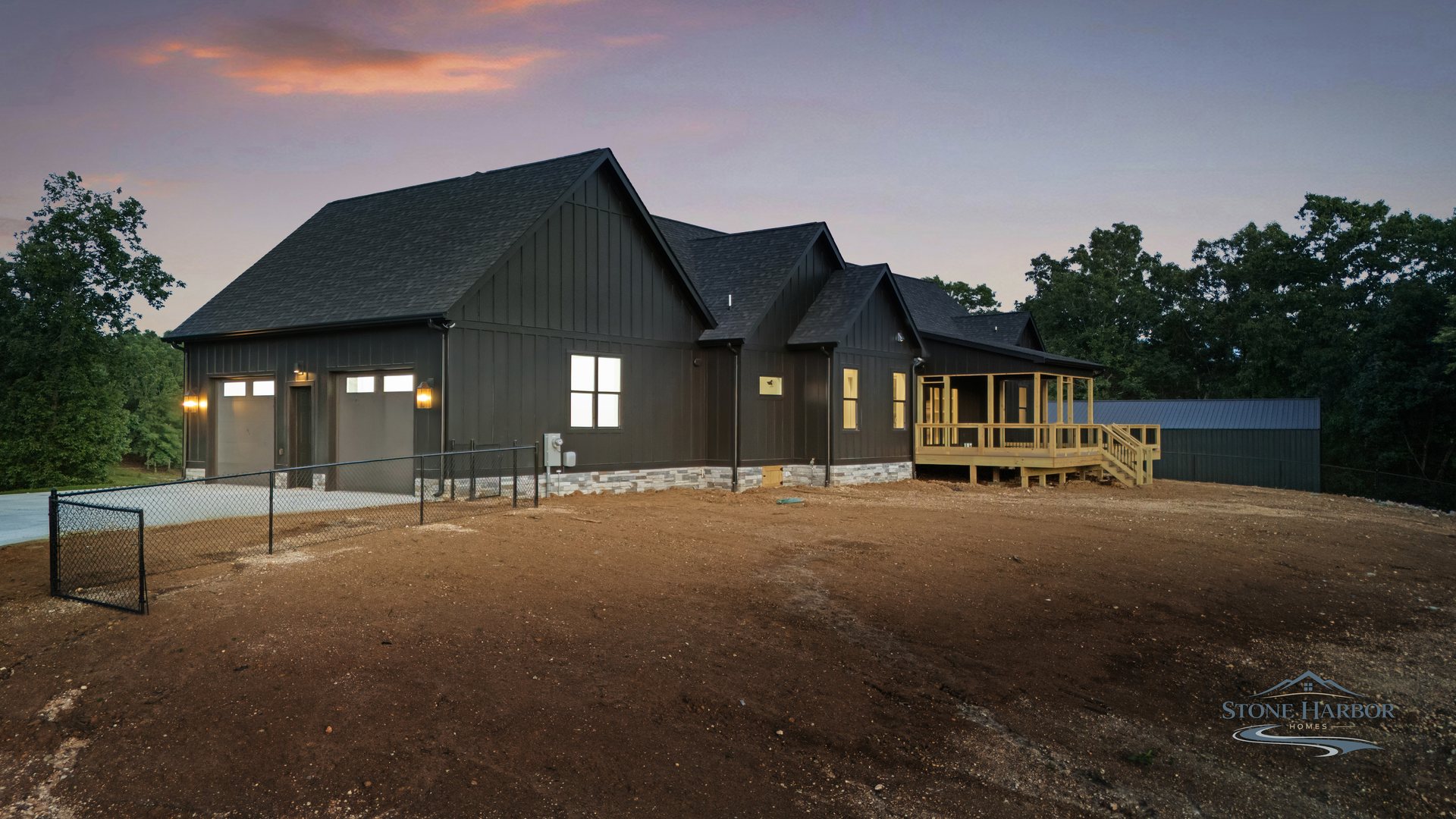 Rear exterior at dusk with the covered deck and detached garage