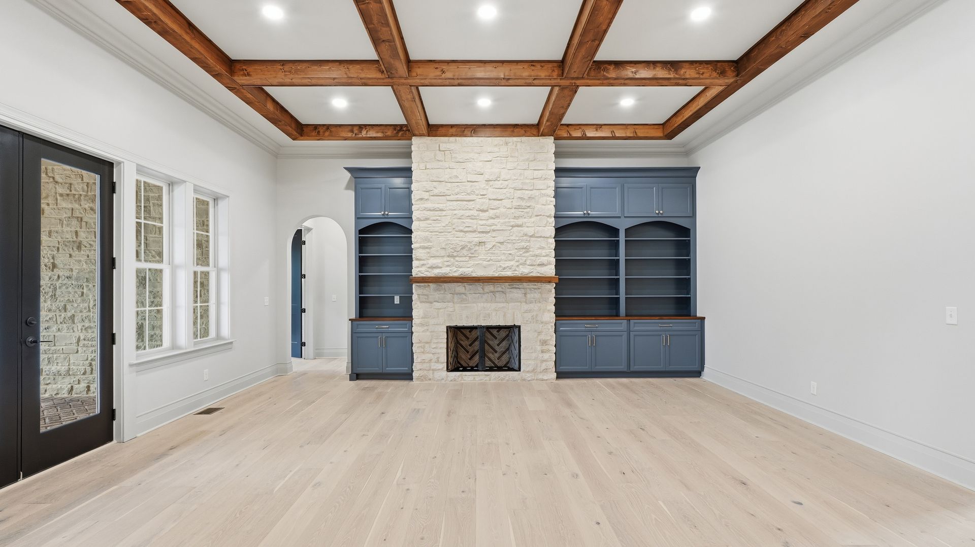 Hixson great room with coffered beamed ceiling and stone fireplace
