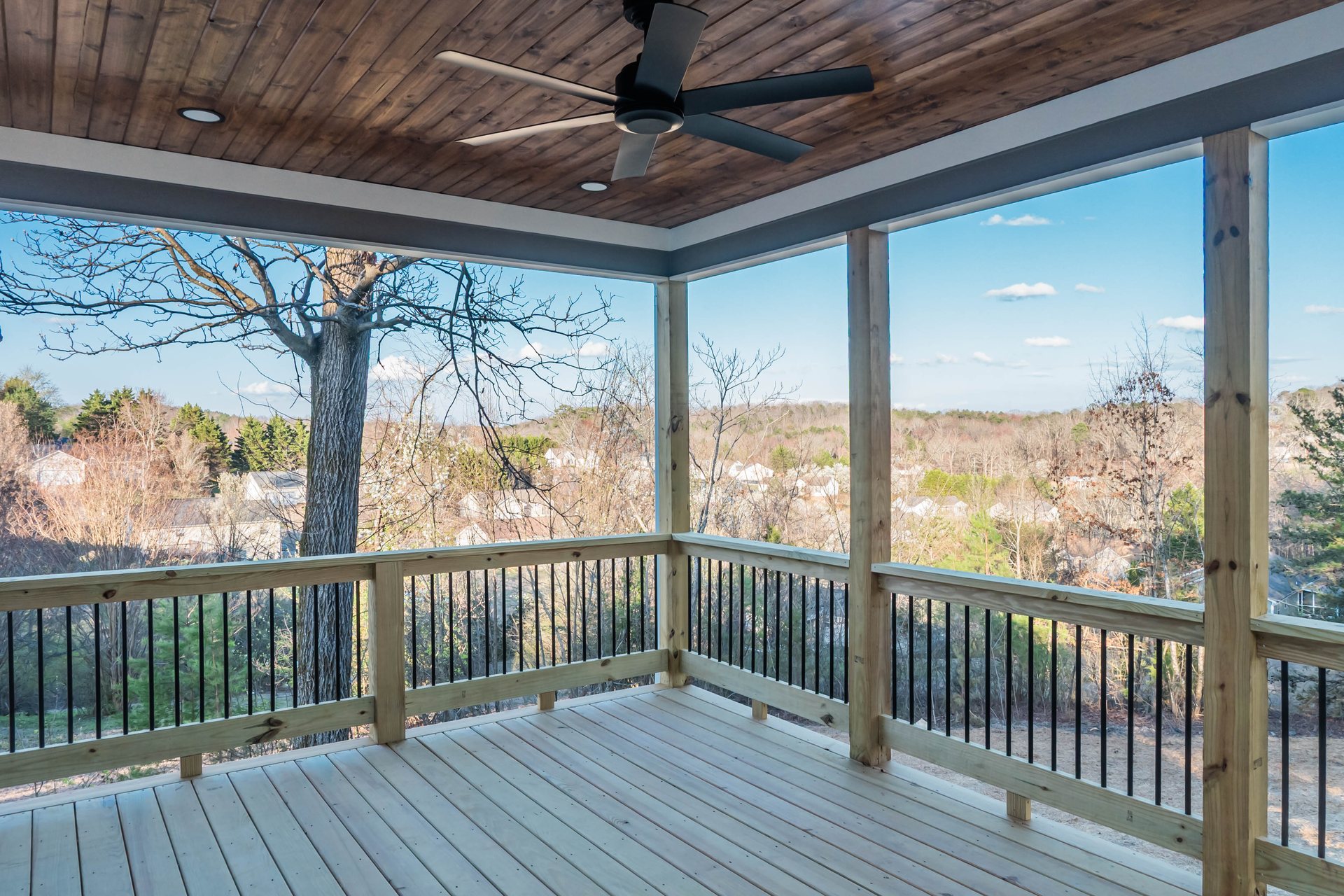 Lightning Drive covered rear porch with a wood ceiling overlooking the trees