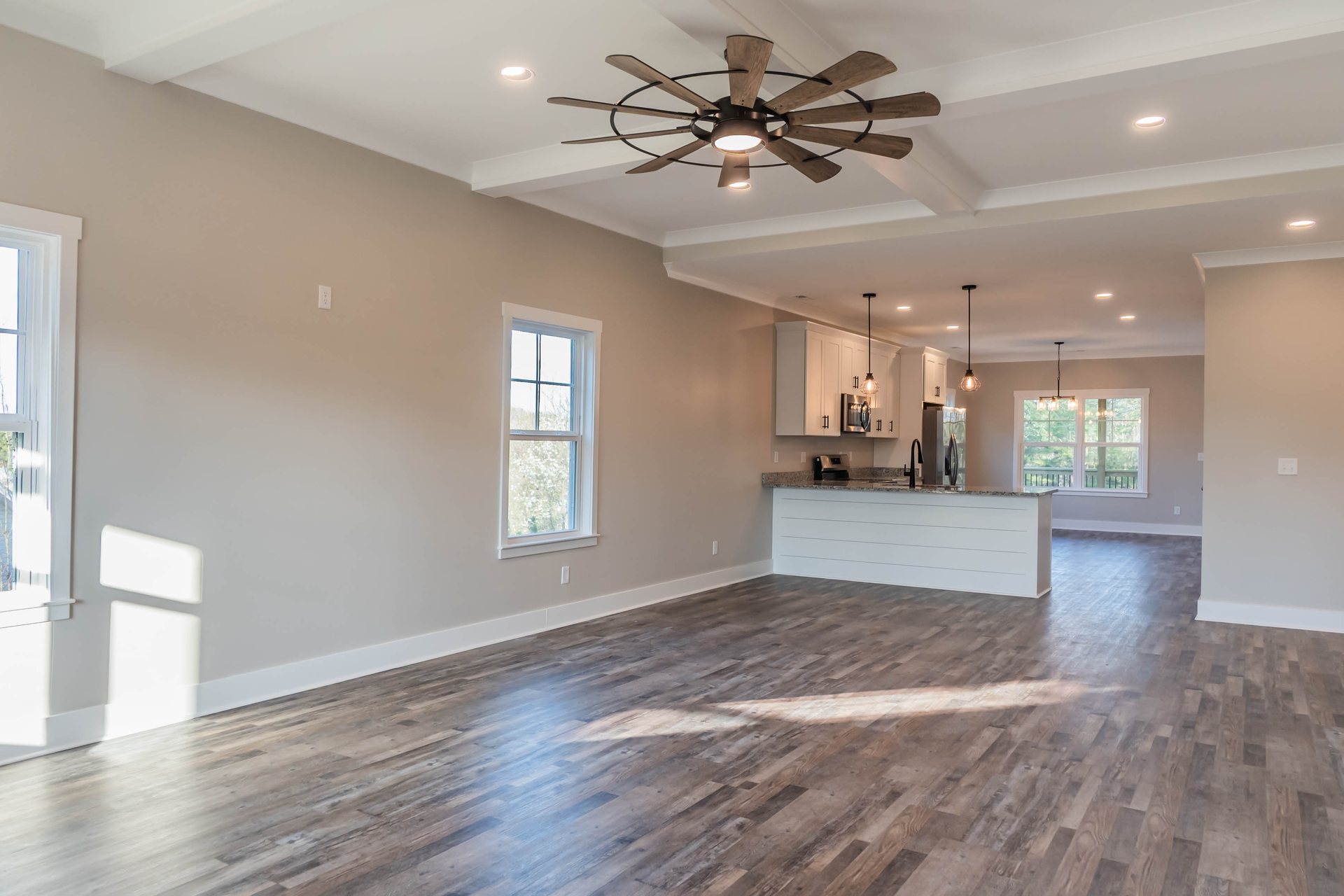 Lightning Drive great room with a tray ceiling and wood-look flooring